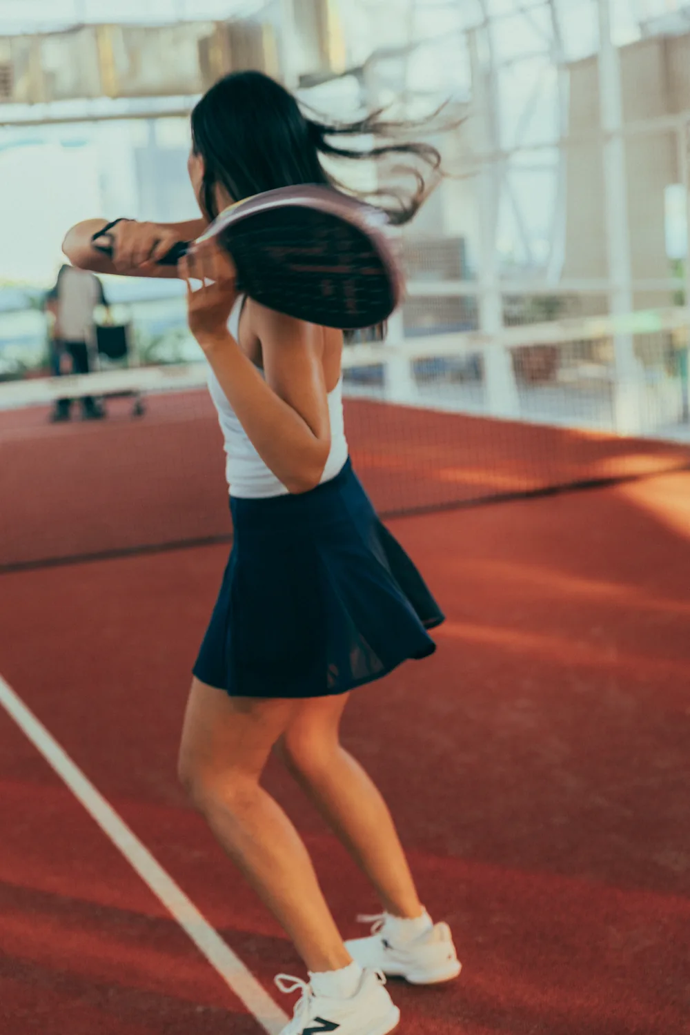 A player preparing a backhand on a PPPLATZ court