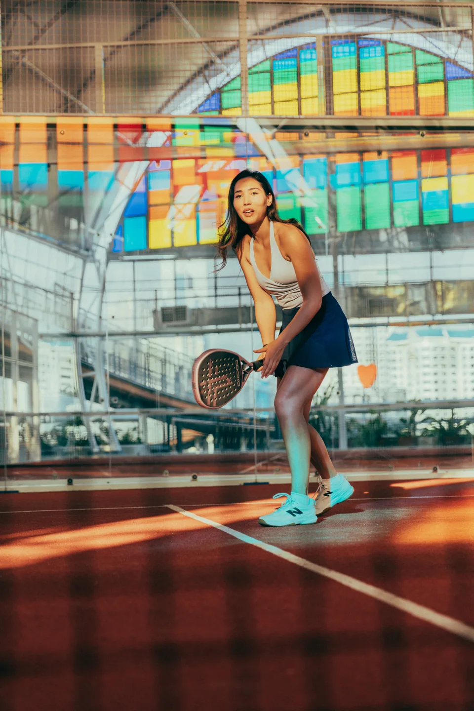 A player holding a racket on PPPLATZ's terracotta padel court